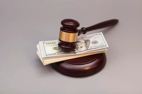 Law gavel on a stack of dollars isolated on gray 스톡 사진