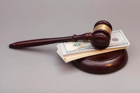Law gavel on a stack of dollars isolated on gray background 스톡 사진