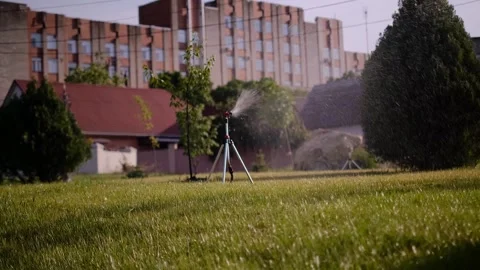 Lawn irrigation system, lawn sprinkler for watering grass in operation, sprays w Stock Footage 245361920