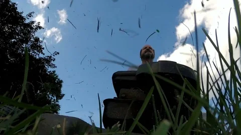 Lawn mower being pushed over a camera on the grass Stock Footage 77079978