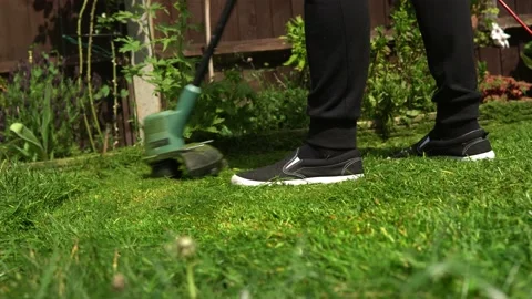 Lawn mower cutting grass. Small Green grass cuttings fly out of lawnmower pushed Stock Footage 194046974