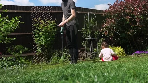 Lawn mower cutting grass. Small Green grass cuttings fly out of lawnmower pushed Stock Footage 194053862