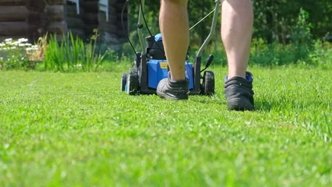 Lawn mower cutting grass. Small grass cuttings fly out of lawnmower. Stock Footage 246917987