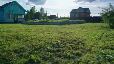 Lawn mower moving through tall grass in a backyard Video stock 337829694