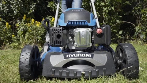 Lawn Mower viewed from front as it moves across lawn and cuts grass Stock Footage 111396581