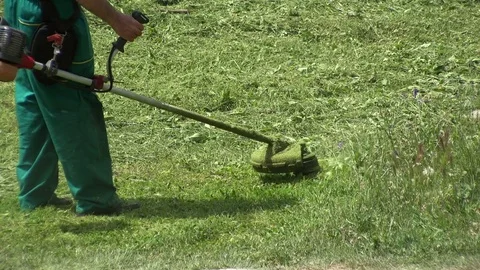 Lawn mower worker man cutting grass in green field Stock Footage 77873710
