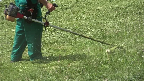 Lawn mower worker man cutting grass in green field Stock Footage 77873797