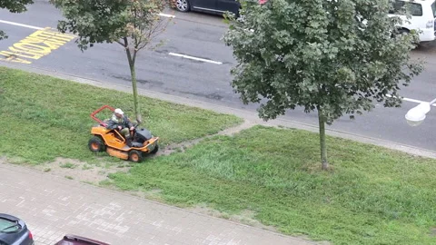 Lawn mowing. A worker driving a self-propelled mower. Mows the grass on the s Stock Footage 138140066