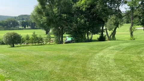 A lawnmower cuts the grass on the golf course Stock Footage 247798213
