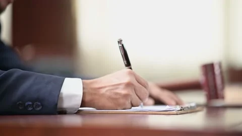 The lawyer is carrying a pen to write a case record in the courtroom Stock Footage 137517100