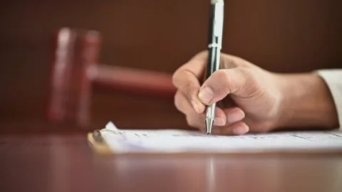 The lawyer is carrying a pen to write a case record in the courtroom Stock Footage 137517101