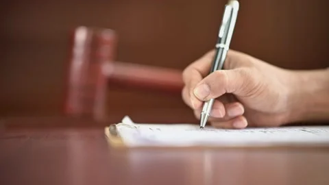 The lawyer is carrying a pen to write a case record in the courtroom Stock-Footage 137517103