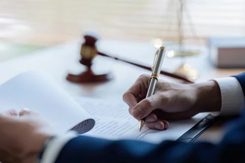 Lawyer leafing through documents and signing contract at work in office Foto stock