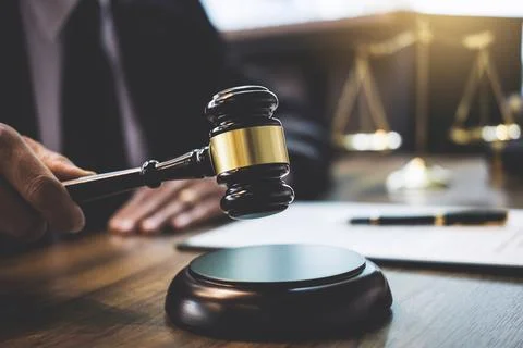 Lawyer or counselor working on a documents and holding gavel in Courtroom, .. Fotos de archivo