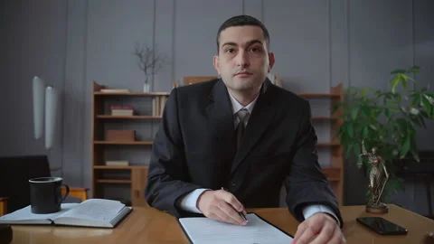 Lawyer or executive checking contract and sitting at table during online call in Stock Footage 170305480