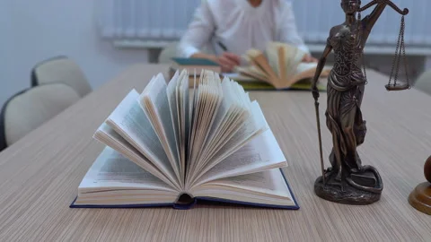A lawyer in the workplace examines documents and legislation, the statuette of Stock Footage 99529661