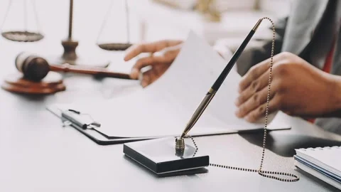 Lawyer write drafts a legal document at a desk with stationery and a laptop.. Stock Footage 304846984