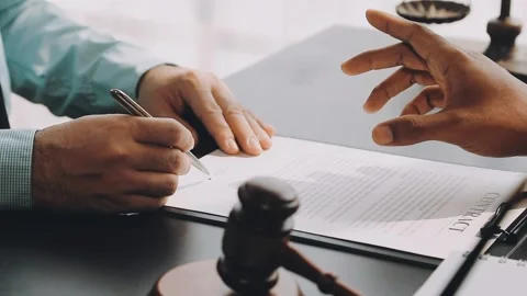 Lawyer write drafts a legal document at a desk with stationery and a laptop.. Stock Footage 304846990