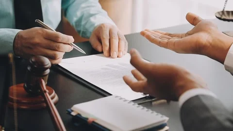 Lawyer write drafts a legal document at a desk with stationery and a laptop.. Stock Footage 304846991
