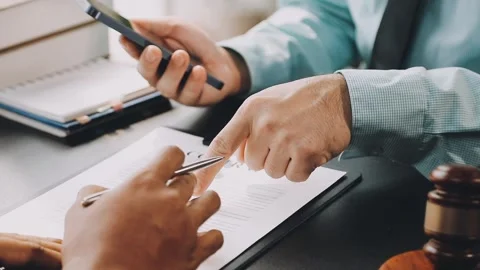 Lawyer write drafts a legal document at a desk with stationery and a laptop.. Stock Footage 304847014
