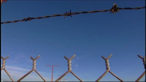 LAX plane lands over barbed wire V1-0025 Stock Footage 76197951