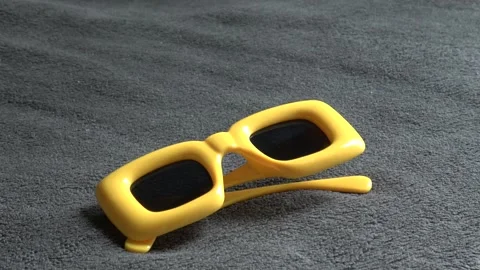Lay down yellow funny sunglasses on carpet. Video stock 312091017