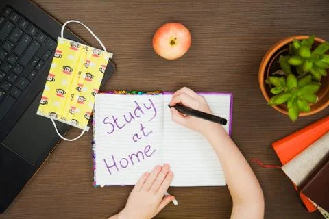 Lay flat image child hands medical antiviral mask write study at home 库存照片