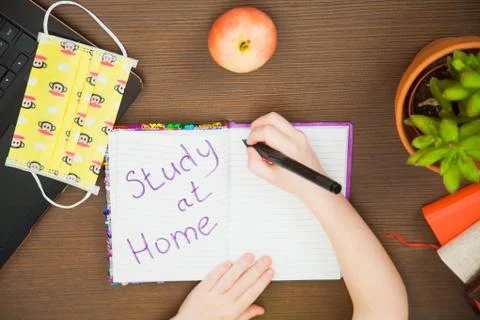 Lay flat image child hands medical antiviral mask write study at home 库存照片