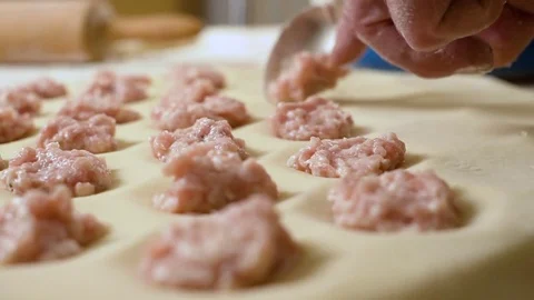 Lay out the stuffing with a spoon and finger on the dough Stock Footage 80043988