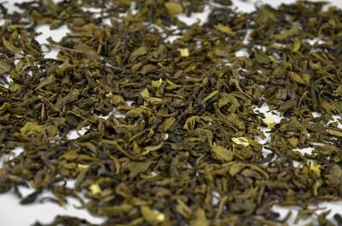 Layer of dry green leaf tea on a white background, closeup (macro), side view Stock Photos