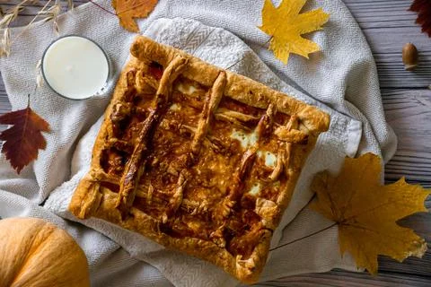 Layer pie with pumpkin for a holiday on a light wooden background with textil Stock Photos