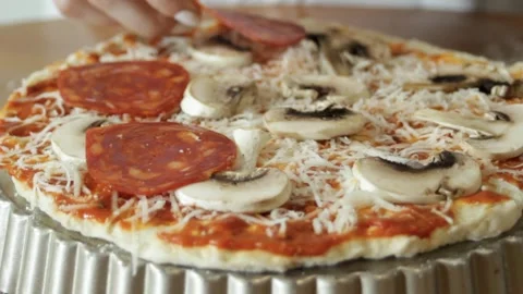 Layer the sausage rings on the pizza base. Slices of spicy pepperoni sausage are Stock Footage 315028743