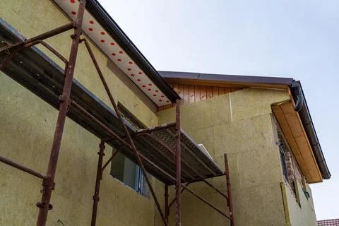 Layer of thermal insulation on the wall of the house outside. Mineral wool pa Stock Photos
