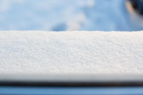 Layer of white snow lying on the windowsill in sunny winter weather. View from Stock Photos