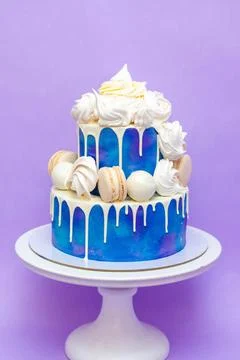 Layered blue cake on cake stand on a purple background. A picture for a men.. Stock Photos