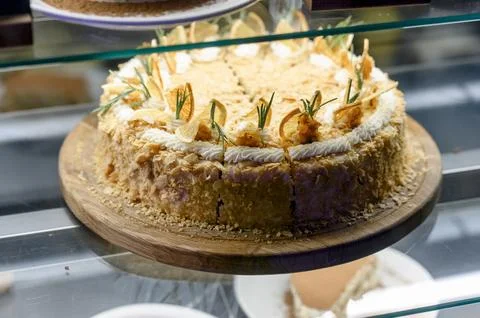 Layered cake displayed in bakery case with decorative elements and pricing 库存照片