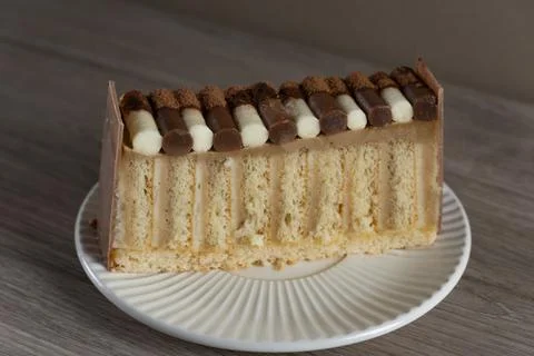 Layered cake slice with chocolate and cream topping Stock-Fotos