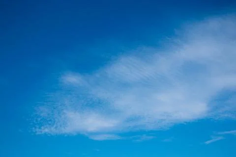 Layered clouds against the background of a bright blue sky in clear weather Stock Photos