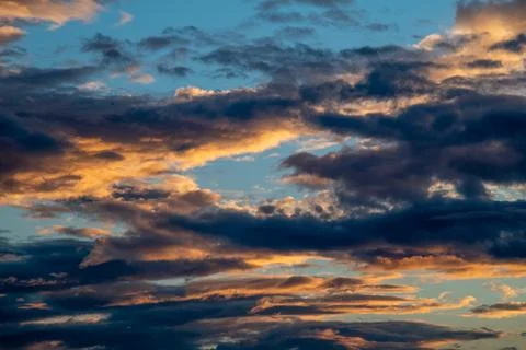 Layered clouds forming a dramatic sky during a vibrant sunset or sunrise Stock Photos