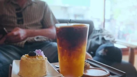 Layered drink of espresso and iced orange juice in a glass with orange slice and Stock Footage 315855353