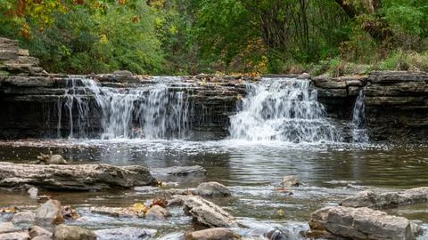 Layered Flow: Low-Shutter Waterfall Cascading Through Rocky Stream Stock Photos