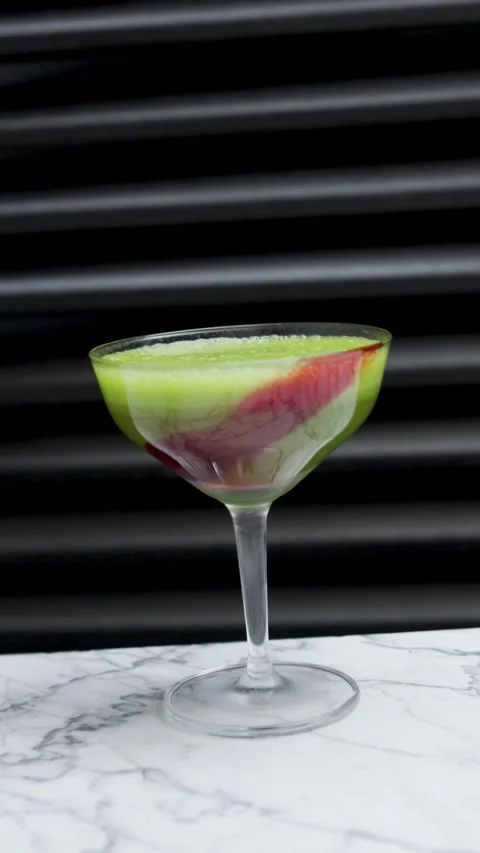 Layered Fruit Smoothie Cocktail in a Coupe Glass on Marble Surface. Vertica.. Stock Footage 333915341