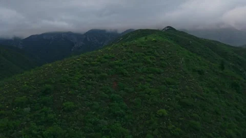 Layered mountain peaks beneath low cloud, moody cinematic aerial Stock Footage 342335668
