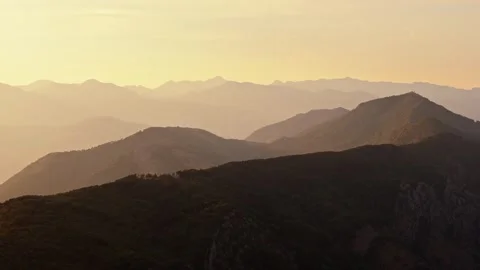 Layered Mountain Ridges in Golden Sunset Haze Aerial View Stock Footage 345529567