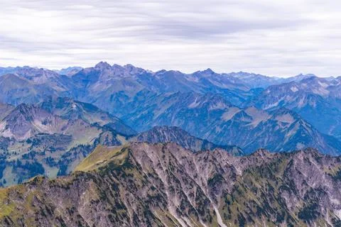 Layered Mountain Ridges Under Soft Clouds Stock Photos