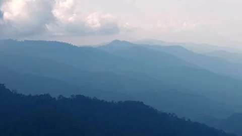 Layered mountains stretch into the distance under soft clouds Video stock 339857553
