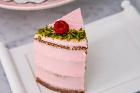 Layered Raspberry Pistachio Cake slice frosted with light pink cream and ga.. Stock Photos