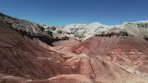 Layered red and white rock formations with deep erosion in Altyn Emel Stock Footage 345410101