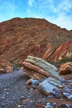 Layered Rock Formations and Dramatic Desert Hillside Under Blue Sky Stock Photos