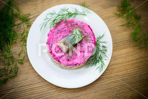 Layered salad of boiled vegetables with beets and herring Stock Photos